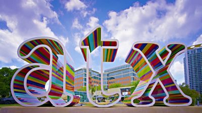 Colorfully striped ATX sign in front of Austin skyline